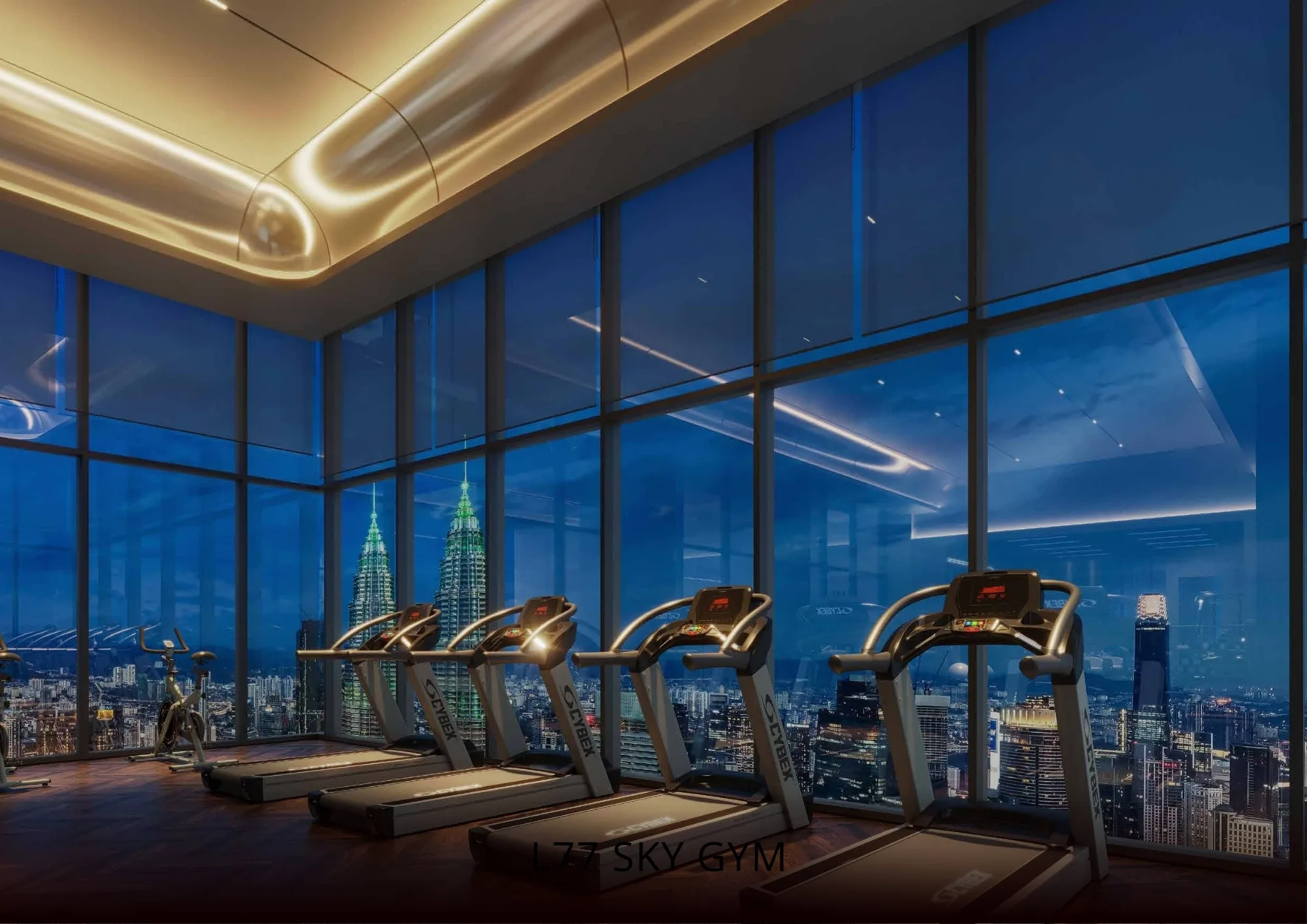 Gim Langit L77 Armani Hallson dengan mesin treadmill menghadap tingkap penuh memandang Menara Berkembar Petronas waktu malam