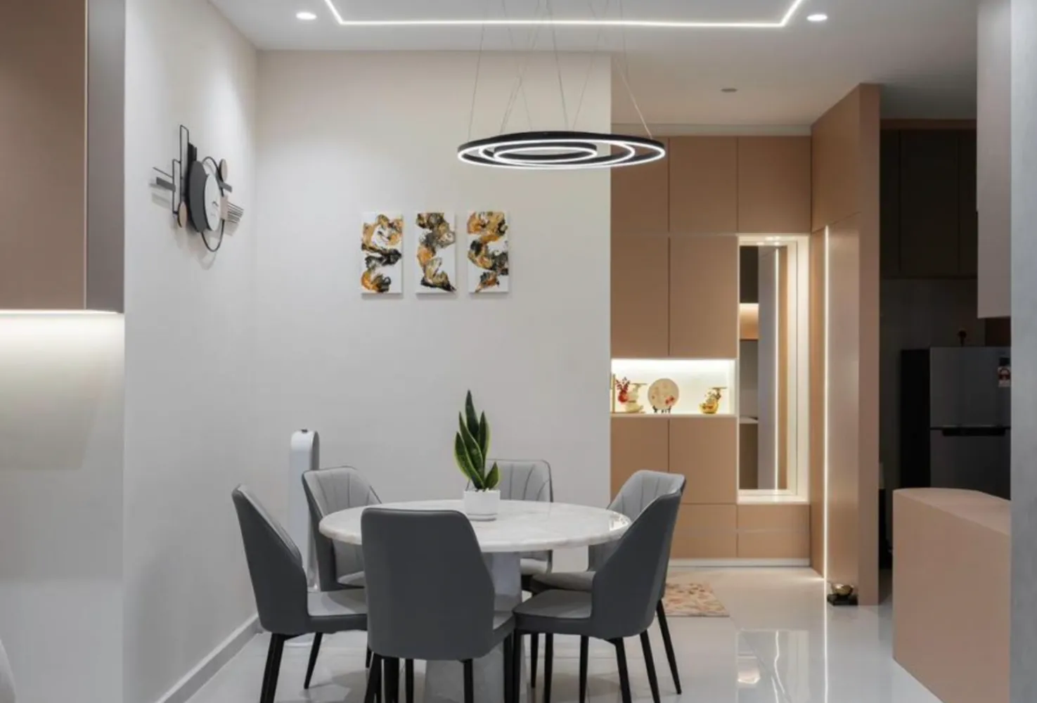 Ruang makan unit contoh dengan meja makan bulat marmar dan lampu di Country Garden Danga Bay