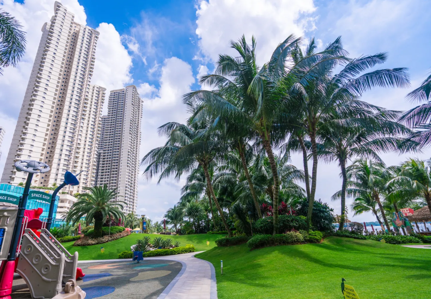 Taman permainan bertema kapal angkasa berlatarbelakangkan pokok kelapa dan menara Country Garden Danga Bay