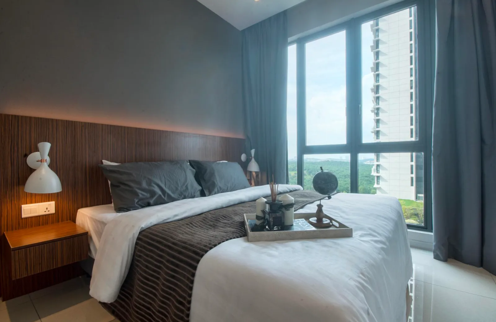 Bilik tidur berperabot di Elysia Park Residence dengan tingkap dari lantai ke siling menghadap kehijauan dan skyline Medini