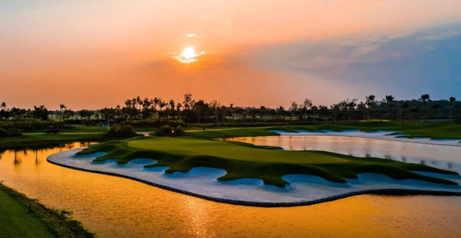Green dan bunker Jack Nicklaus Legacy Golf Course pada waktu senja, bersempadan dengan Forest City Nigella Park