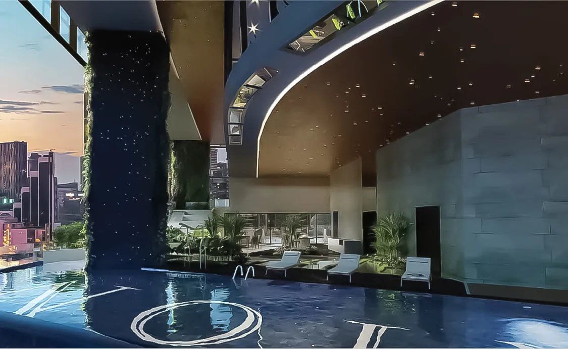 Orion Residence night view along infinity lap pool featuring tiled O logo, starlit ceiling, and sun loungers, from the official developer website in Bukit Bintang, Kuala Lumpur