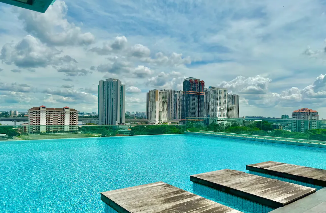 Paragon Suites @ CIQ infinity pool deck with wooden day beds overlooking the city skyline in Stulang Laut, Johor Bahru City Centre, Johor