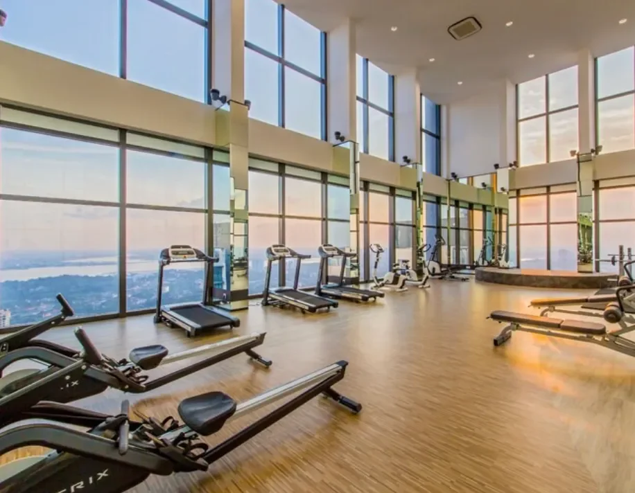 Ruang gimnasium Setia Sky 88 dengan peralatan kardio dan kekuatan menghadap skyline bandar