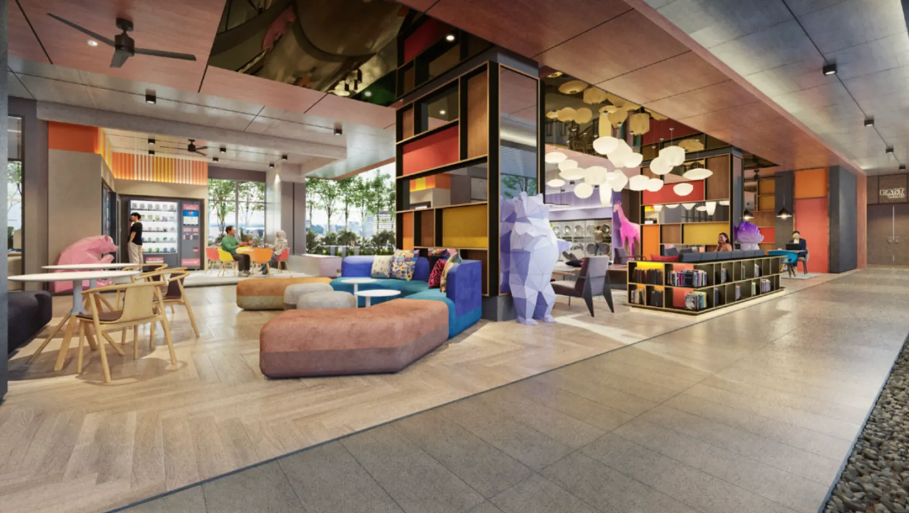 Lounge sosial berwarna-warni dan sudut coworking Summer Suites dengan rak perpustakaan