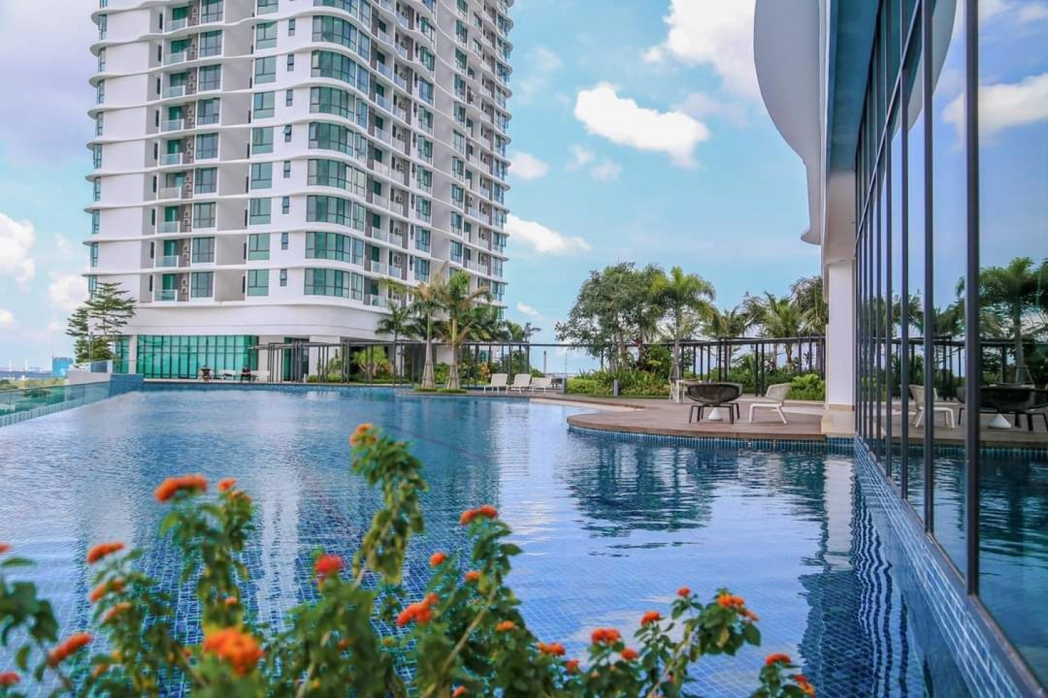 The M Macrolink Medini infinity pool deck by daytime with tower and skyline backdrop in Medini, Iskandar Puteri, Johor