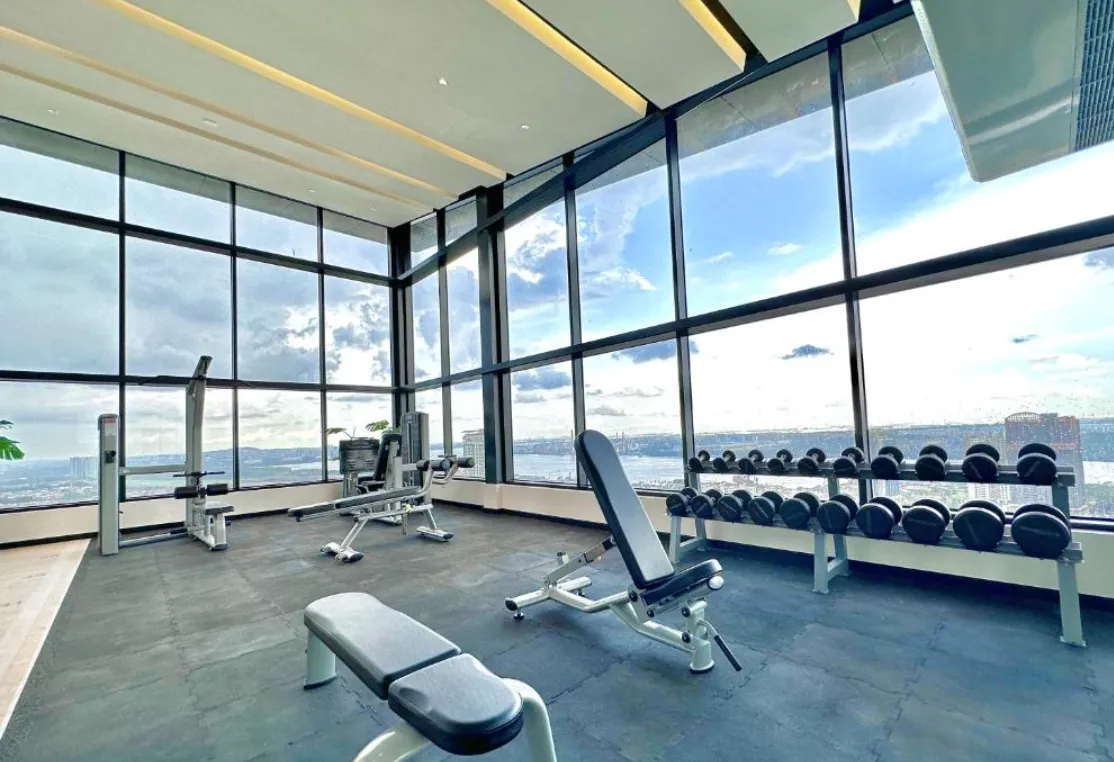 Twin Tower Residence gymnasium with floor-to-ceiling windows and dumbbell rack in Bukit Chagar, Johor Bahru, Johor