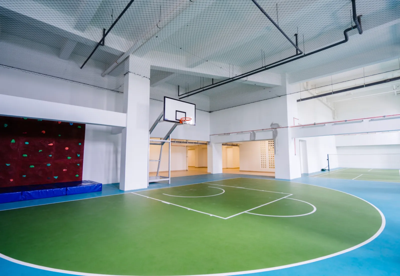 Gelanggang separuh bola keranjang dalaman Wave Marina Cove dengan dinding memanjat dan gelanggang badminton