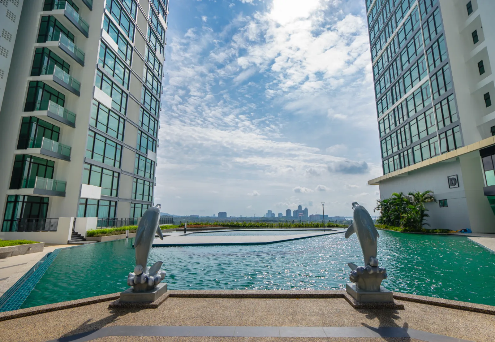 Kolam infiniti bumbung Wave Marina Cove dengan arca lumba-lumba dan pemandangan garis langit Johor Bahru