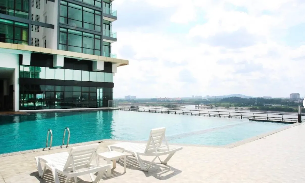 Tepi kolam infiniti Wave Marina Cove menghadap laluan air dengan kerusi santai