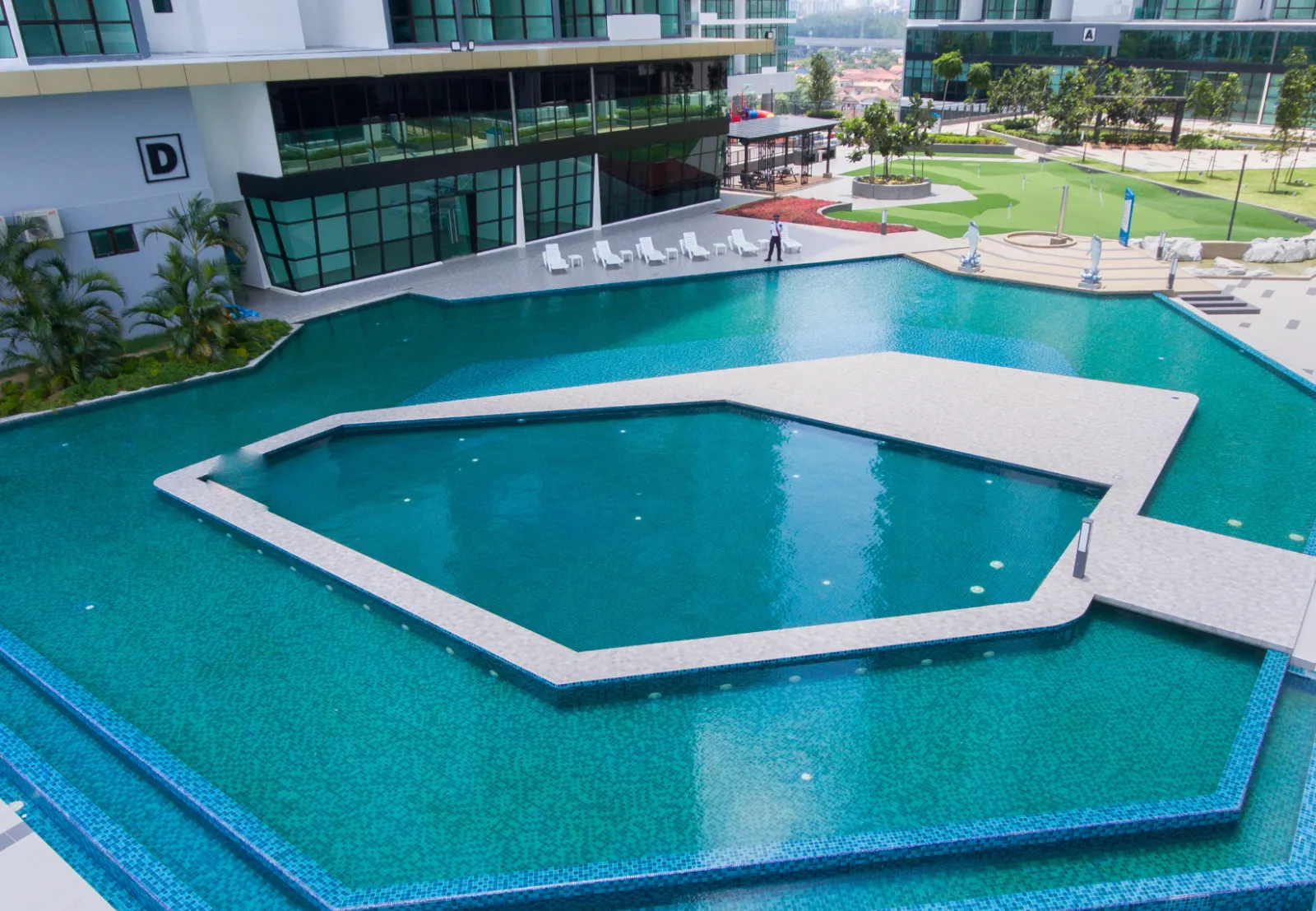 Pandangan udara dek kolam renang utama berbentuk geometri Wave Marina Cove