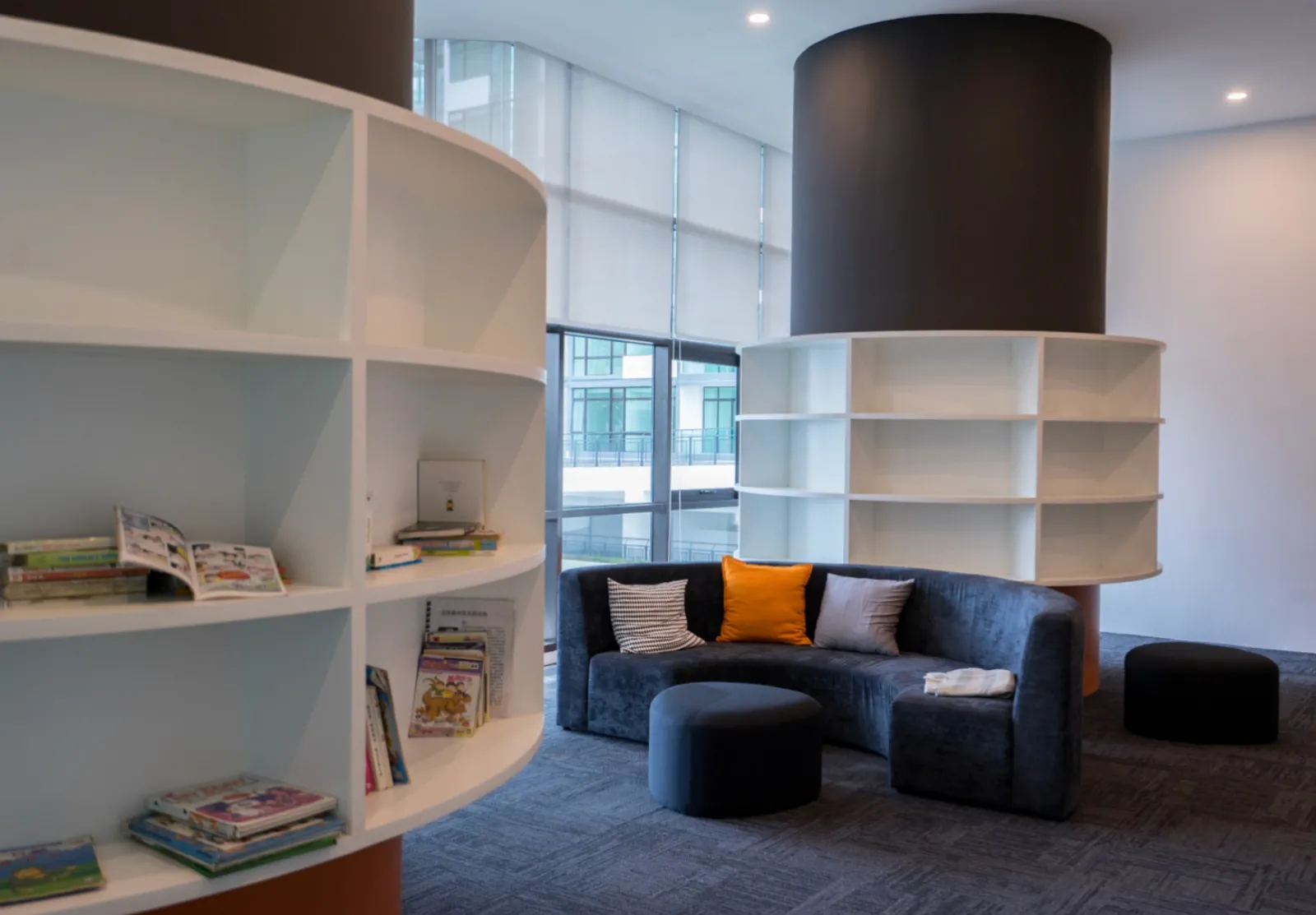 Lounge bacaan Wave Marina Cove dengan rak buku melengkung dan tempat duduk santai